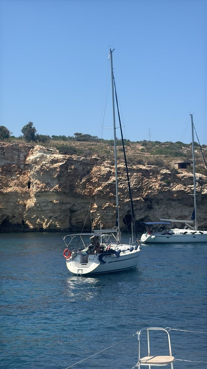 Kahlija anchored beneath Malta's cliffs